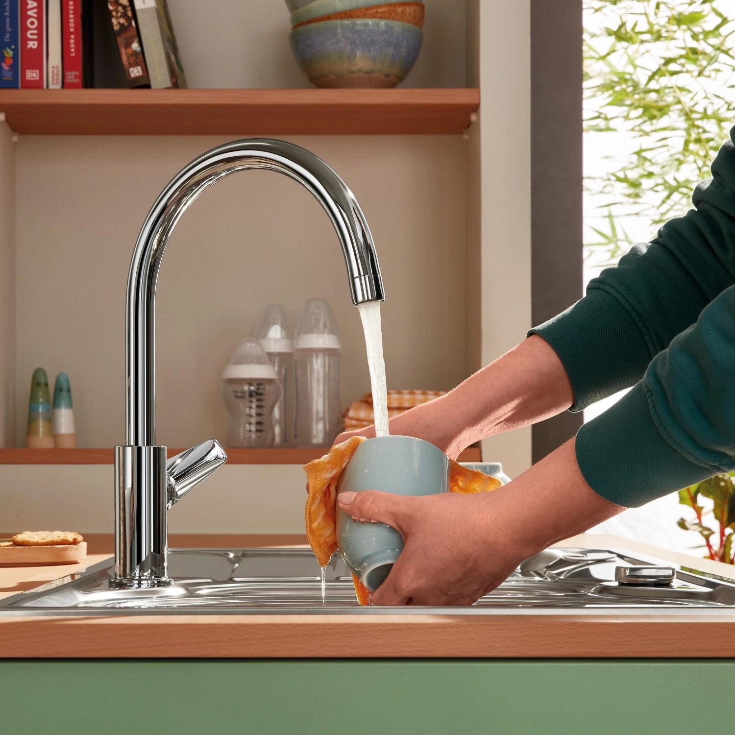 Grohe QuickFix Waschtischarmatur Start Alira Chrom L mit Person beim Abwaschen einer Tasse.