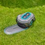 Gardena Mähroboter mit Ladestation auf Rasenfläche. Undercover Schlauchbox RollUp M Komplettset.
