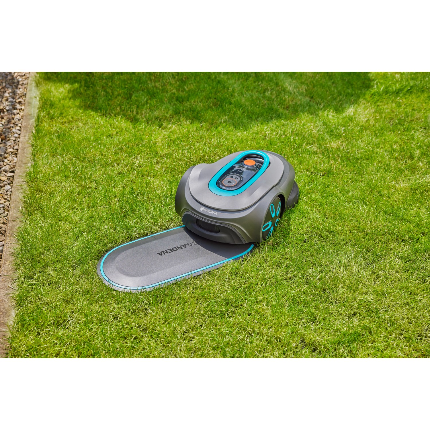 Gardena Mähroboter mit Ladestation auf Rasenfläche. Undercover Schlauchbox RollUp M Komplettset.