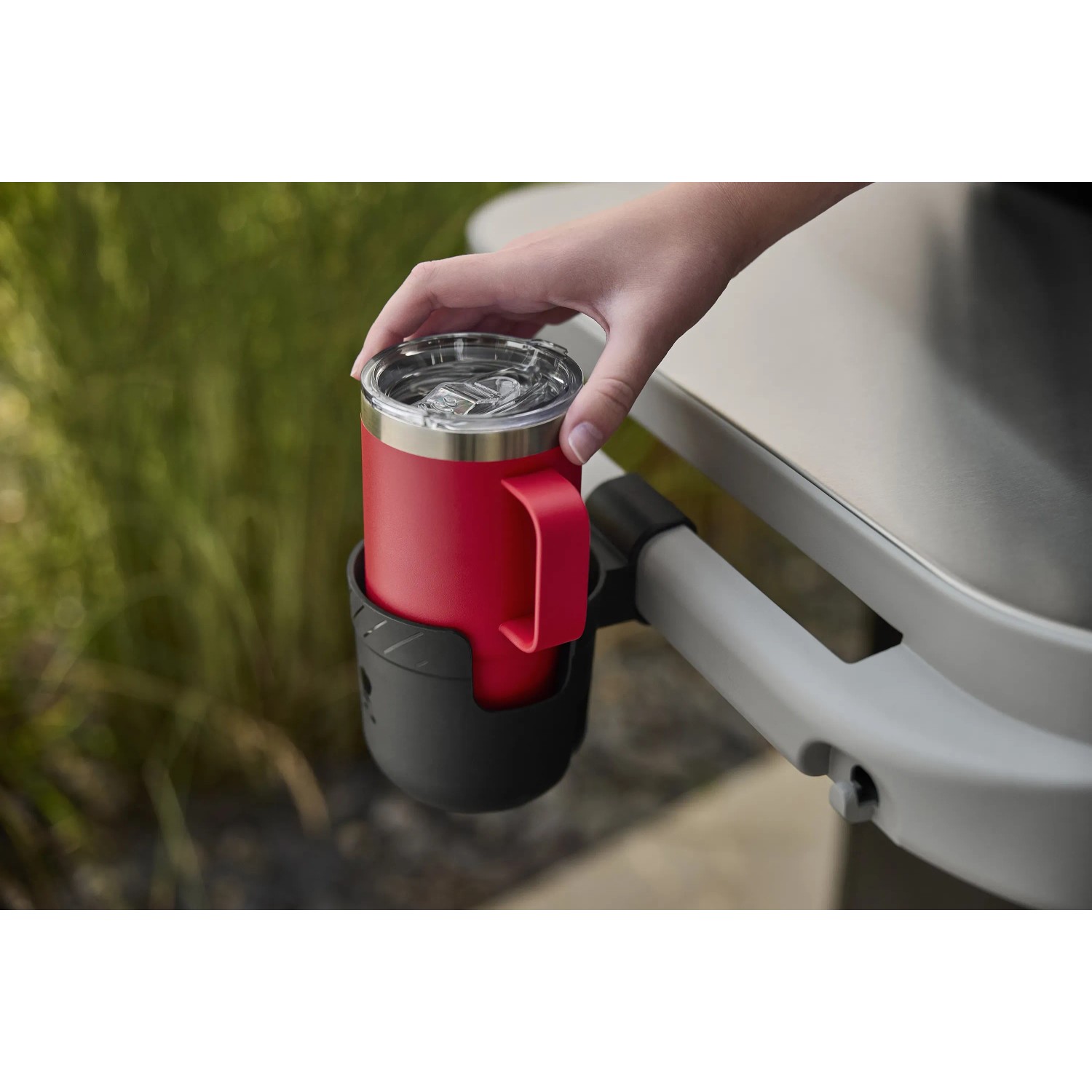 Weber Works Flaschenhalter, eingehängt mit roter Tasse, Grillzubehör.