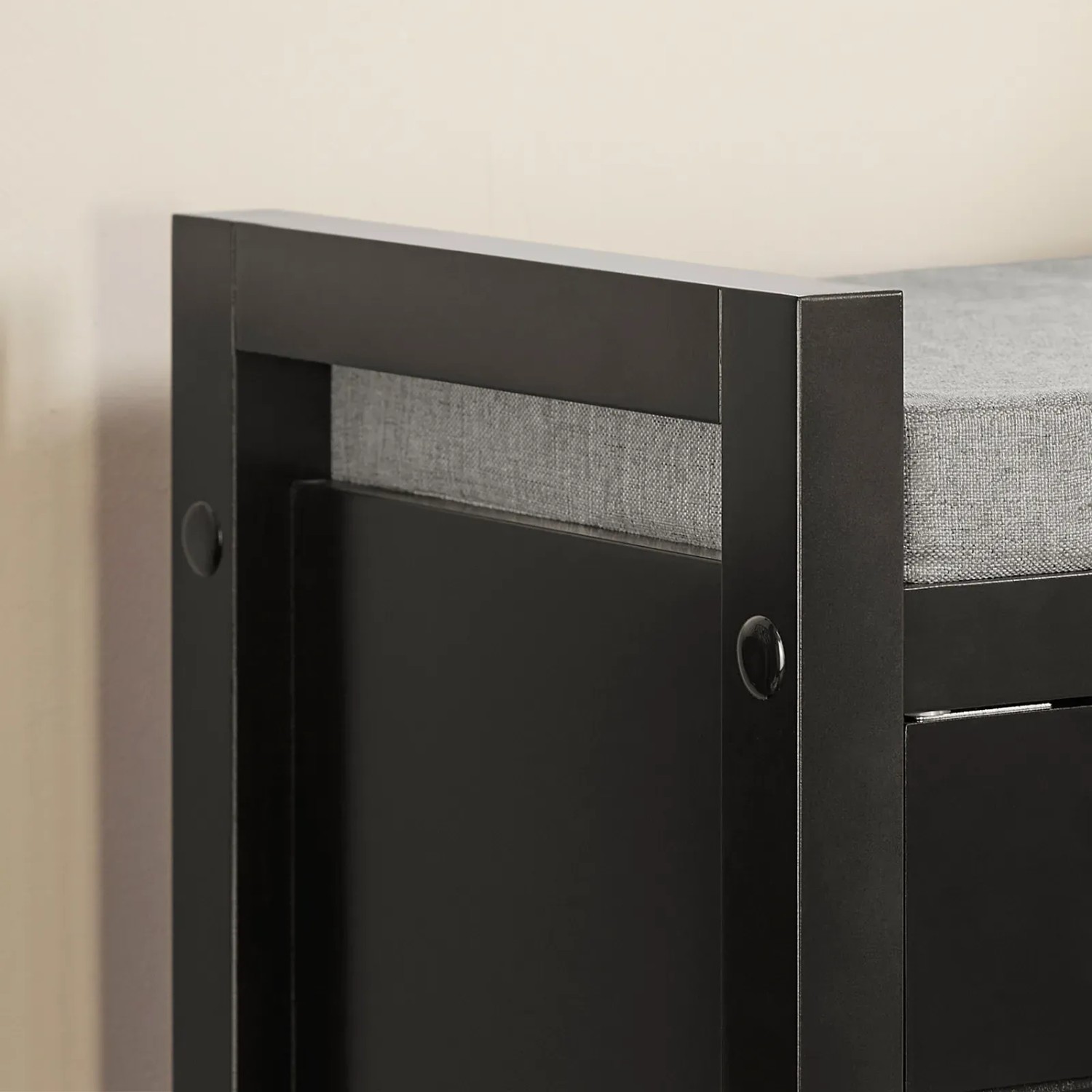 Detailaufnahme: Schwarze Schuhbank mit grauer Sitzfläche und Stauraum.