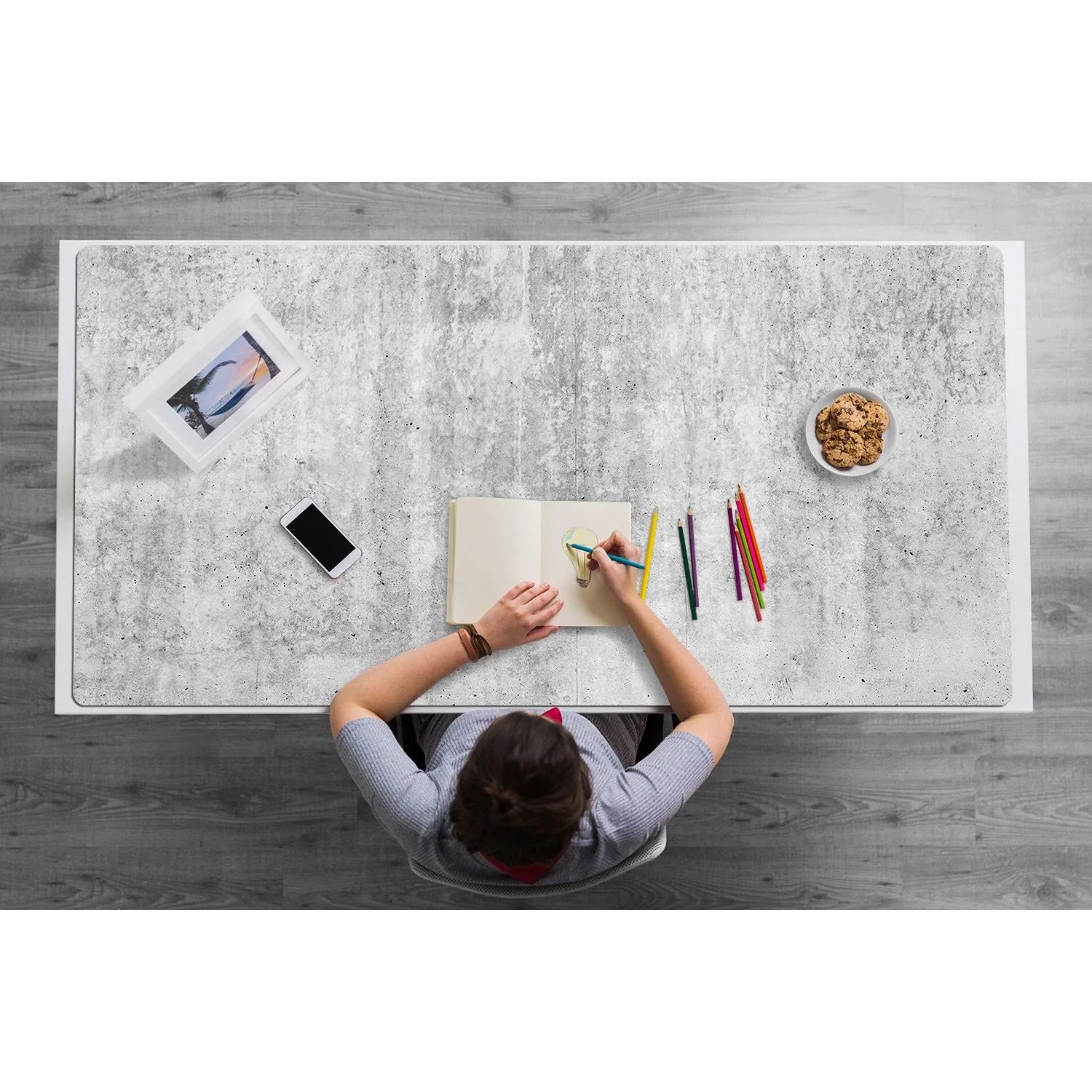 Tulup Schreibtischunterlage Grauer Beton 120x60 cm. Person zeichnet auf Schreibtischmatte im Büro.