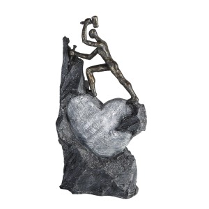 Dekorative Skulptur Heart: Mann meißelt bronzefarbenes Herz aus grauem Kunstharz. Antikfinish, 37 cm hoch.
