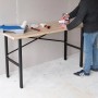 rikta Werkbank (159x85x58cm) mit Holzplatte und schwarzem Stahlgestell, genutzt von einer Person.