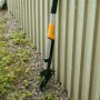 Fiskars Unkrautstecher Ergonomic, orange-schwarz, mit vier Krallen zur Unkrautentfernung im Garten.