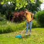 Frau nutzt Gardena combisystem-Teleskopstiel zum Laubrechen im Garten.