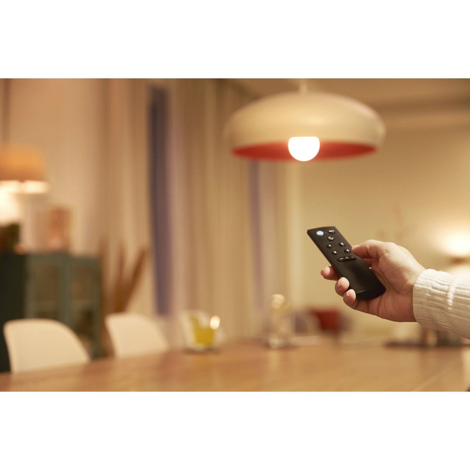Hand steuert mit WiZ Remote eine Lampe. Smarte Fernbedienung für Lampen.