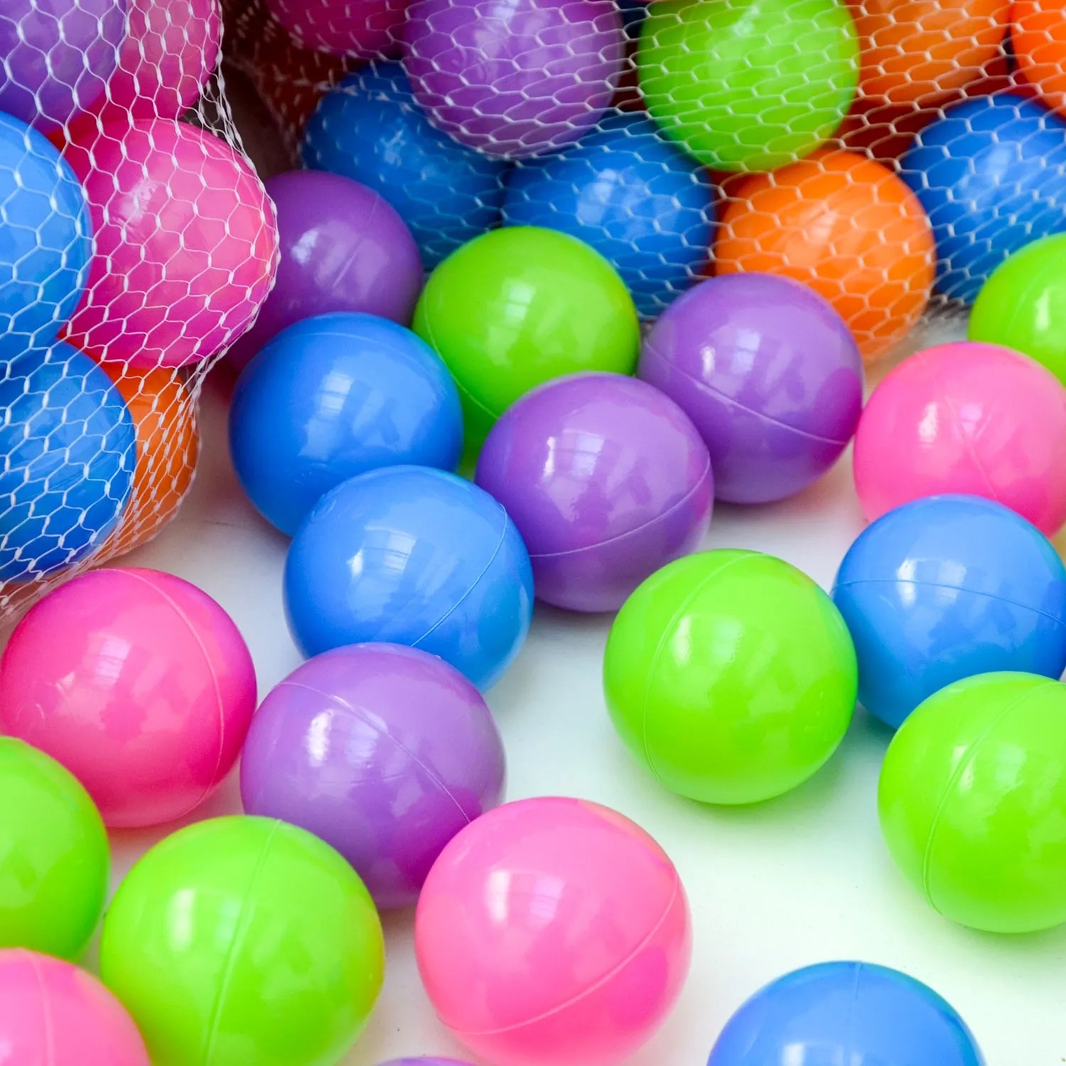 LittleTom Bällebadbälle, 100 Stück in Pastellfarben (pink, lila, blau, grün, orange) im Netz.