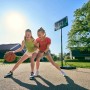 Zwei Mädchen spielen mit dem Salta Basketballständer Forward (108x362cm) im Freien.
