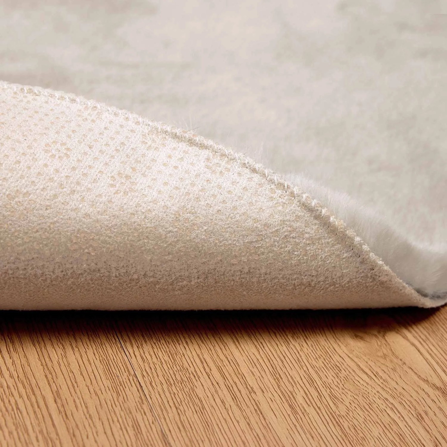 Beiger, runder vidaXL Kunstfell Teppich (Ø 160cm) aus Polyester, Detailansicht der Unterseite.