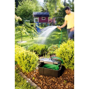 Heissner Garden Power Box im Garten mit Schlauch und Person beim Gießen. Stromverteiler für Teichpumpen.