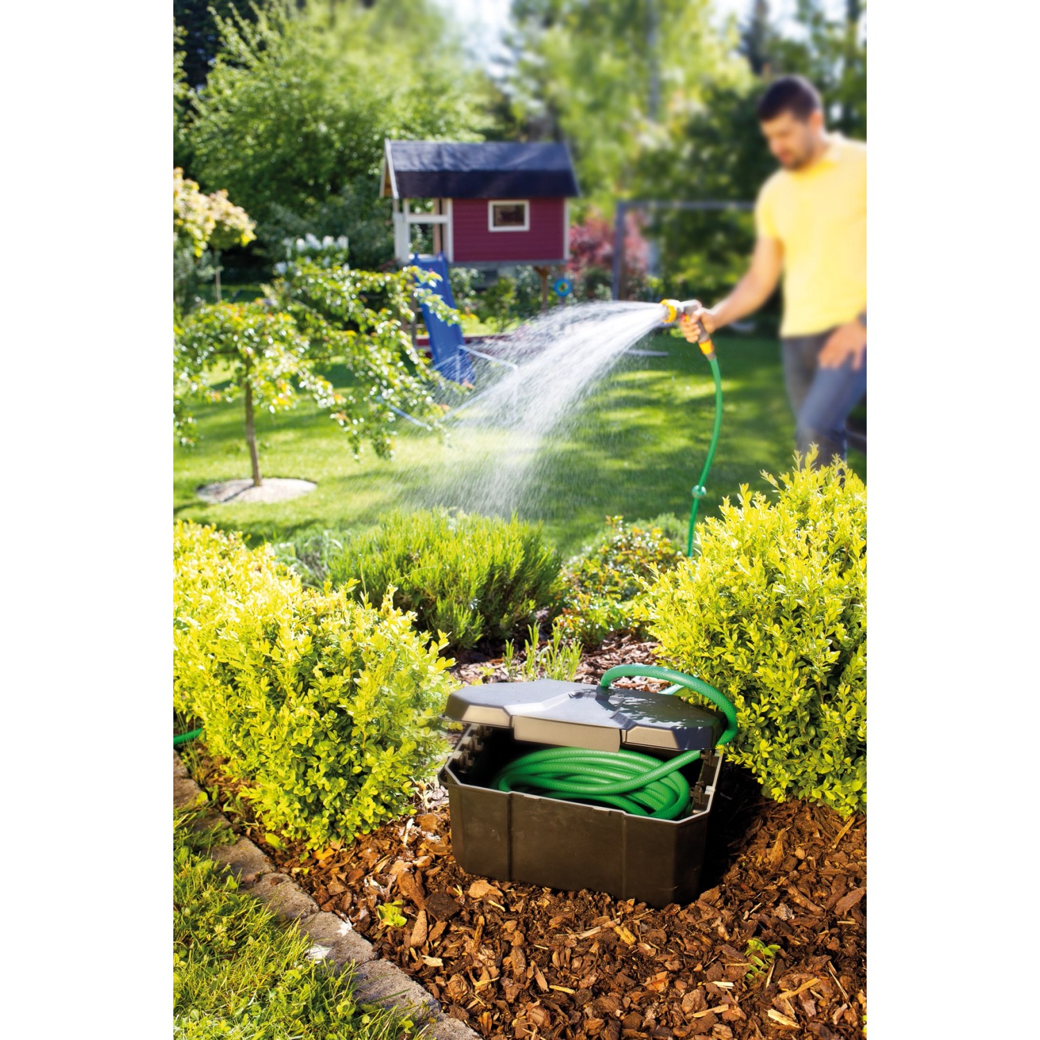 Heissner Garden Power Box im Garten mit Schlauch und Person beim Gießen. Stromverteiler für Teichpumpen.