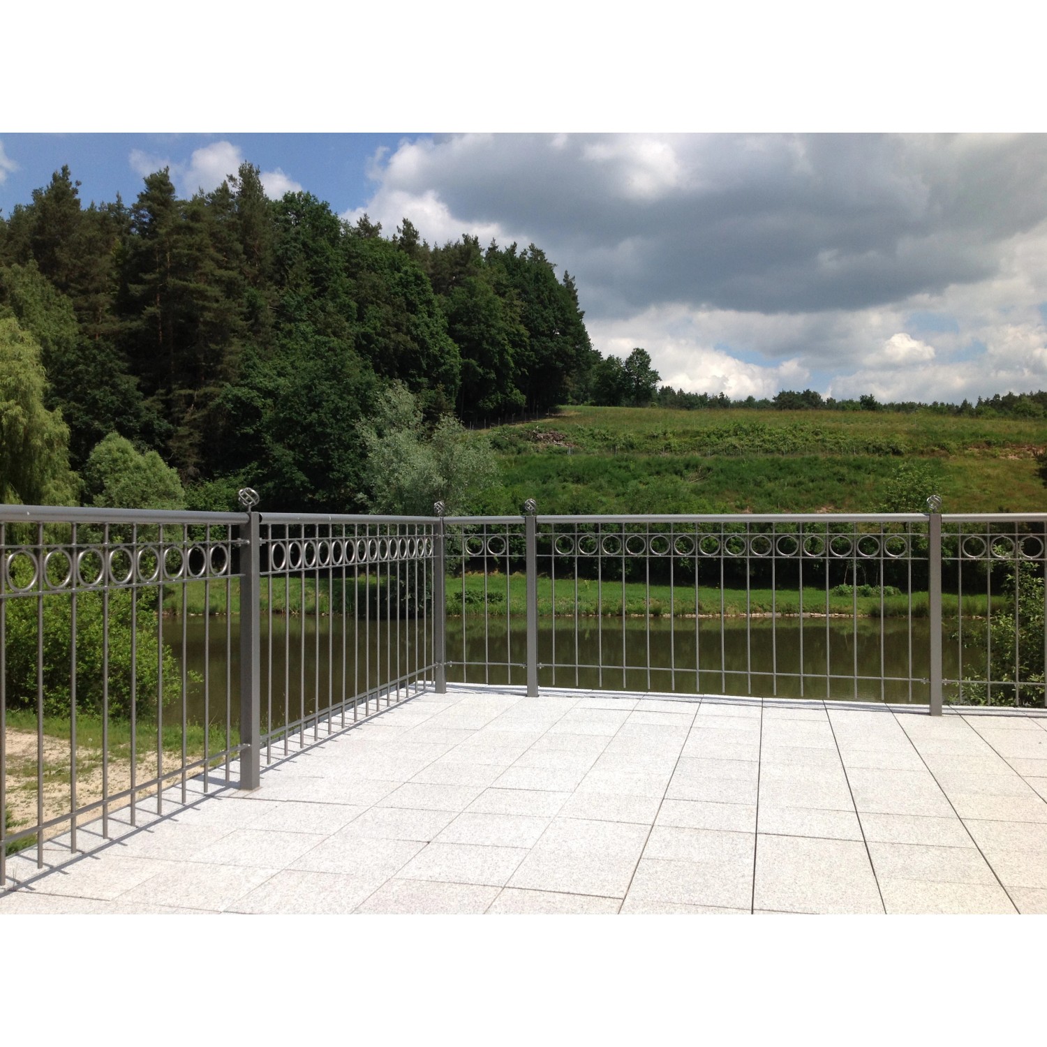 Pulverbeschichtetes Eleo Geländer Belluno, 192,5x90 cm, mit Kreisornamenten vor Landschaft.