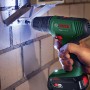 Bosch Akkubohrschrauber EasyDrill 18V-40, grün, bohrt mit LED-Licht in Ziegelwand. Vielseitiger Akkuschrauber.