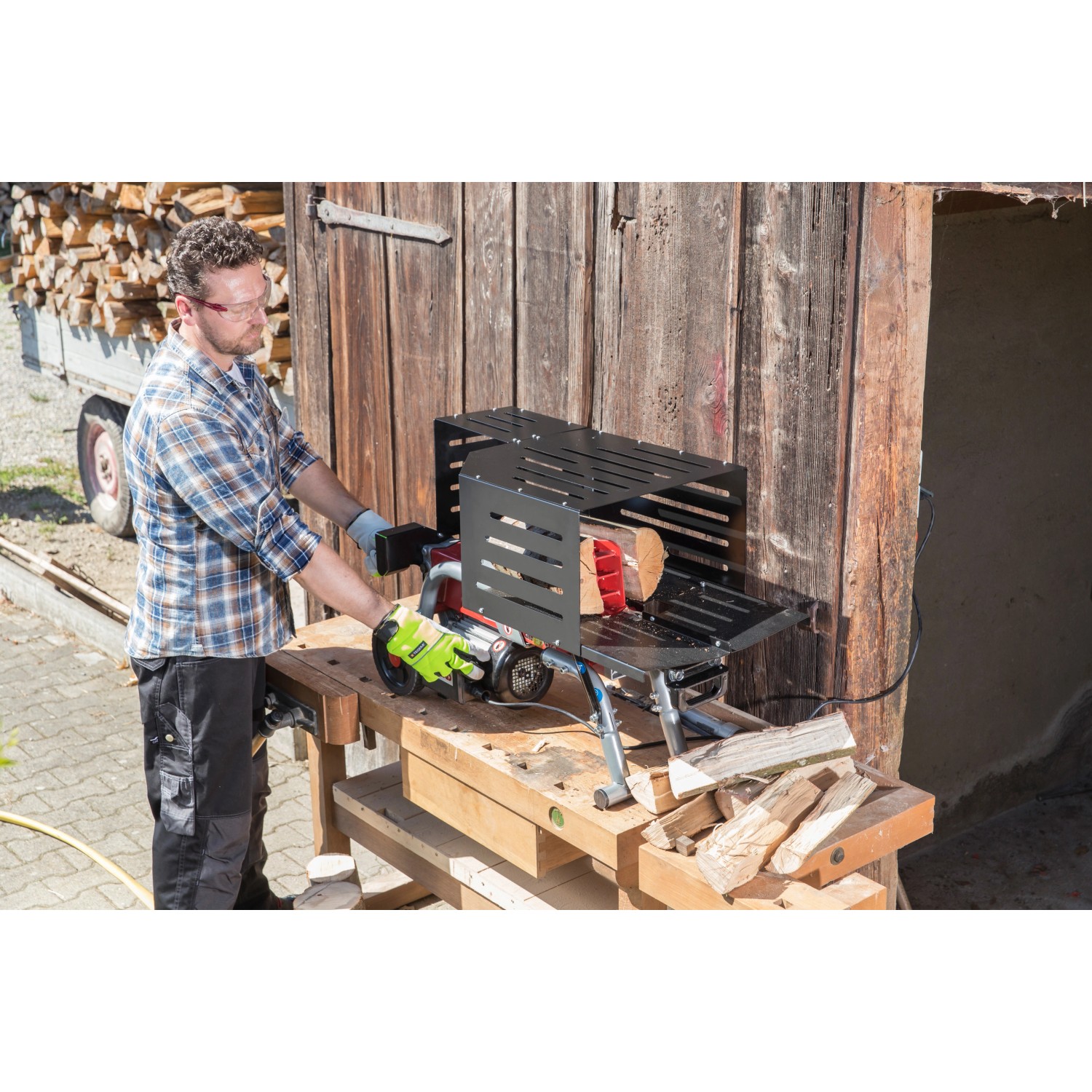 Al-Ko Elektroholzspalter LSH 370/4 in Nutzung: Mann spaltet Holz mit dem liegenden Holzspalter auf einer Werkbank.