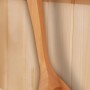Weka Schöpfkelle aus hellem Holz für Saunaaufgüsse, hängend an einer Saunawand.