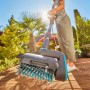 Gardena Akku-Multi-Reiniger AquaBrush Patio in Aktion auf Holzterrasse mit Wasserzufuhr.