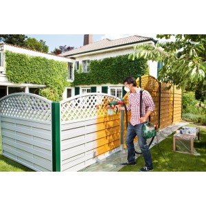 Mann sprüht mit Bosch PFS 3000-2 Feinsprühsystem einen Gartenzaun an.