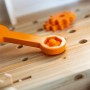 Orangefarbener Spielzeug-Schraubenschlüssel auf OBI Kinderwerkbank aus Holz, Schraube und Zahnräder.