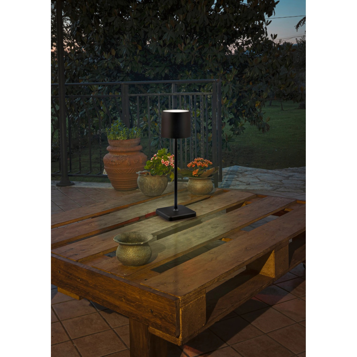 Schwarze Reality LED-Tischleuchte Fernandez auf Gartentisch, Akku-Leuchte mit Touch-Schalter.