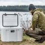 Geöffnete, sandfarbene Petromax Kühlbox 50L neben Person in Outdoor-Szene. Ideal für Camping.