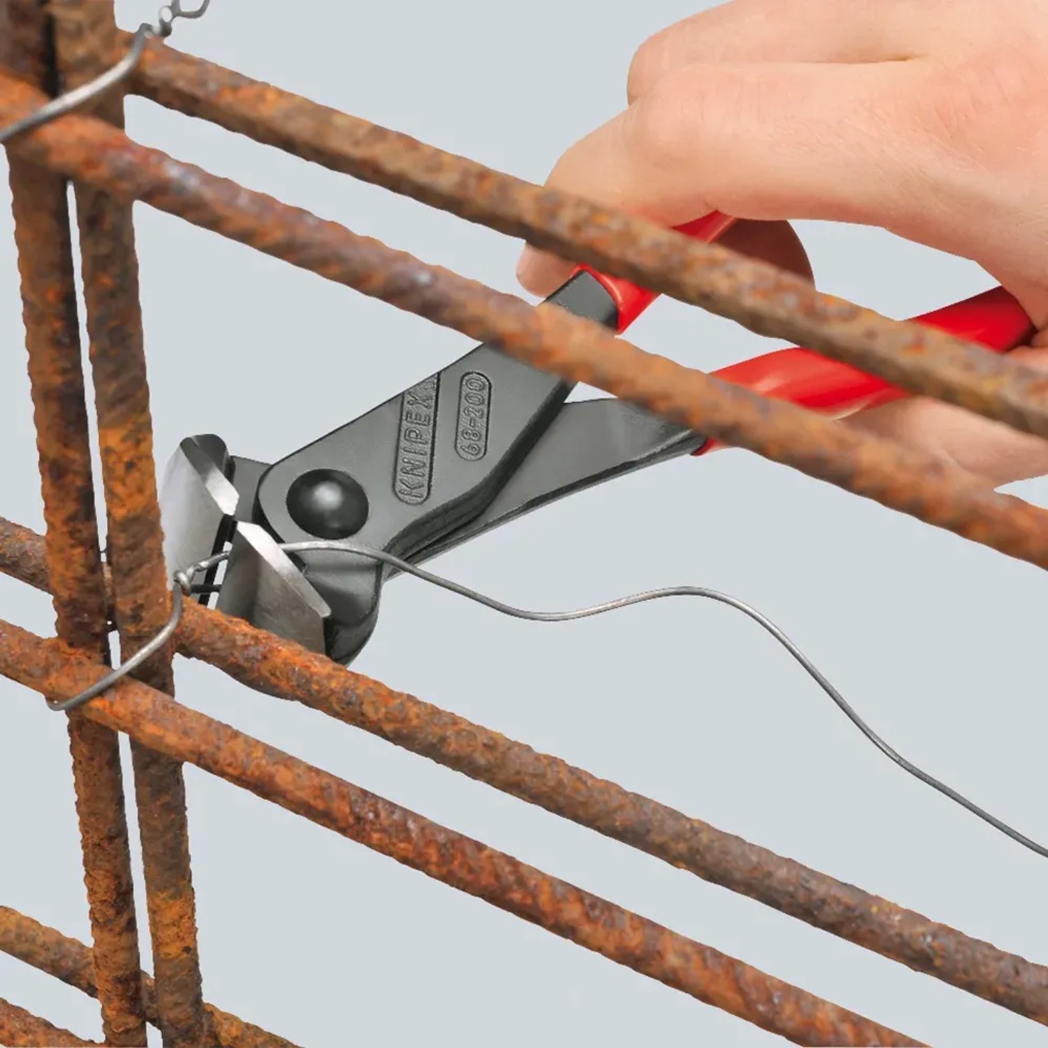 Knipex Vornschneider 160mm beim Draht schneiden. Zange mit schwarzem Kopf und roten Griffen.