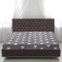 Anthrazitfarbenes Spannbettlaken (160x200) mit weißen Sternen von Bestlivings auf einem Bett.