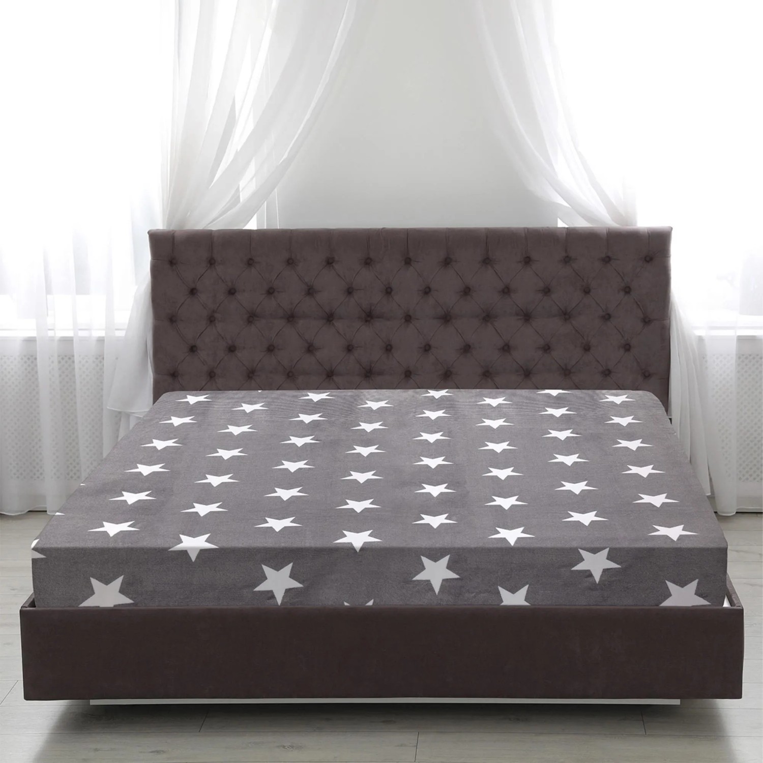Anthrazitfarbenes Spannbettlaken (160x200) mit weißen Sternen von Bestlivings auf einem Bett.