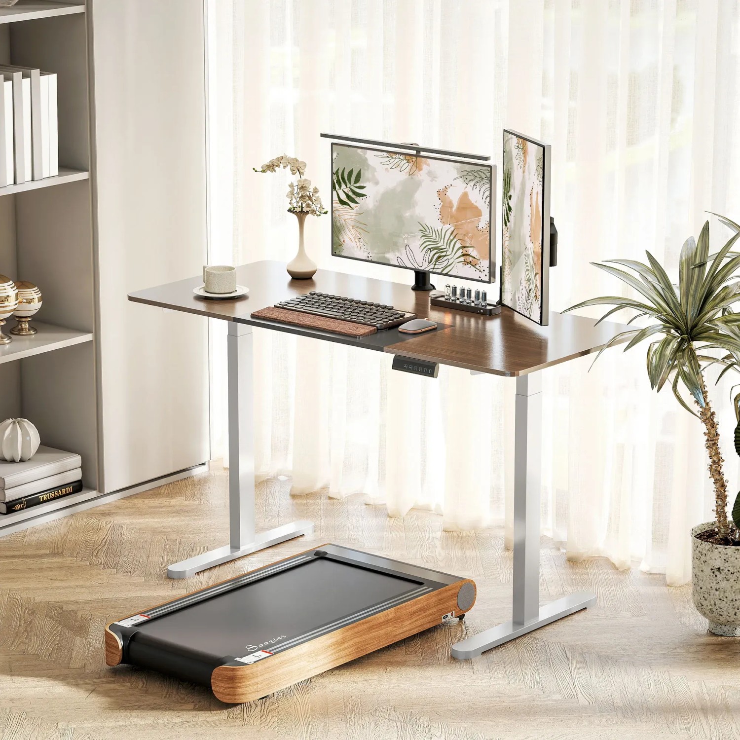 Höhenverstellbarer Schreibtisch mit weißem Gestell, Monitoren, Tastatur und Laufband im Raum.