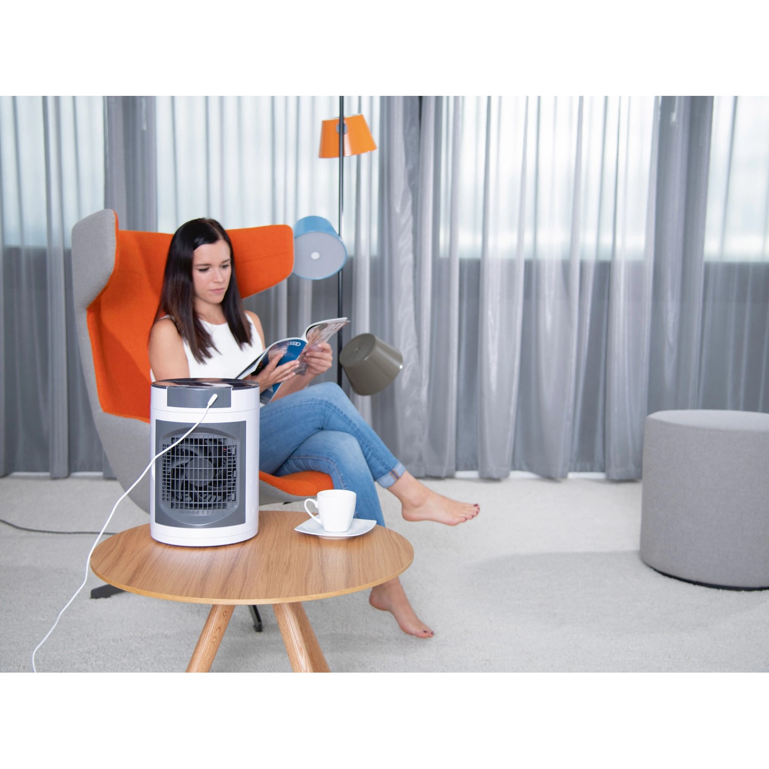 Livington SmartChill Klimagerät auf Tisch, Frau liest im Sessel.