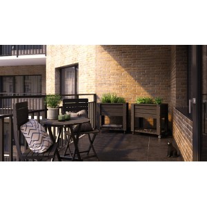 Anthrazitfarbenes Hochbeet auf Rädern (80x50cm) auf einem Balkon mit Tisch und Stühlen.