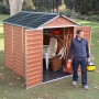 Palram Canopia Gerätehaus Skylight, 185x229 cm, Amber, mit geöffneten Türen und einer Person davor.