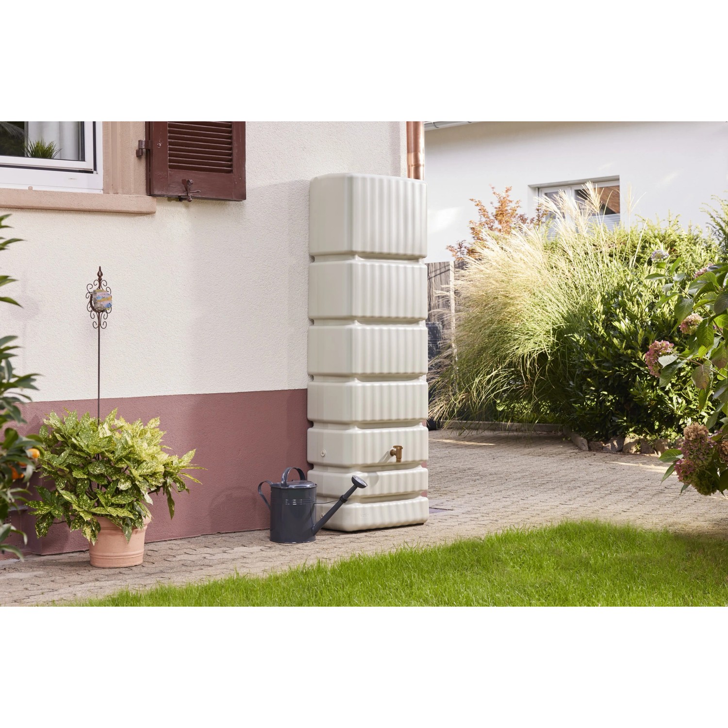 4rain Wandtank Slim 350 l in Sandbeige mit Auslaufhahn an Hauswand. Regentonne für Gartenbewässerung.