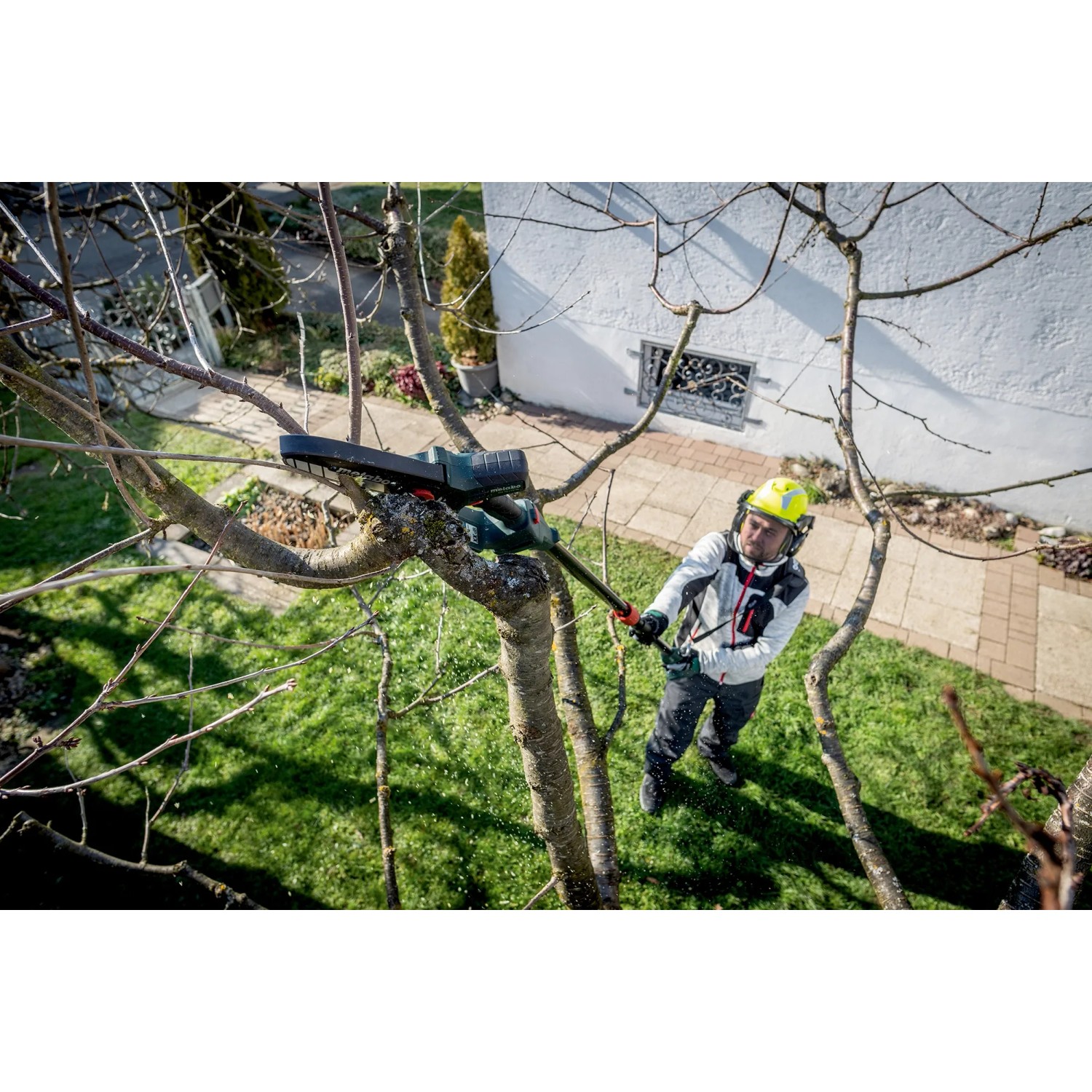 Mann schneidet Baum mit Metabo Akku-Gehölzsäge MS 18 LTX 15. Inkl. Akku, Ladegerät und Tasche.