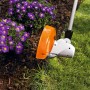 Stihl Elektro-Motorsense FSE 52 trimmt Gras im Garten. Orange-weißer Mähkopf mit Abstandshalter schützt Pflanzen.