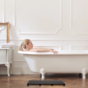 Schwarze Relaxdays Bambus Badematte vor Badewanne im hellen Bad. Rutschfester Badvorleger.