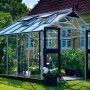 Juliana Premium 10 Gewächshaus aus Aluminium mit geöffneten Türen und Pflanzen im Inneren.