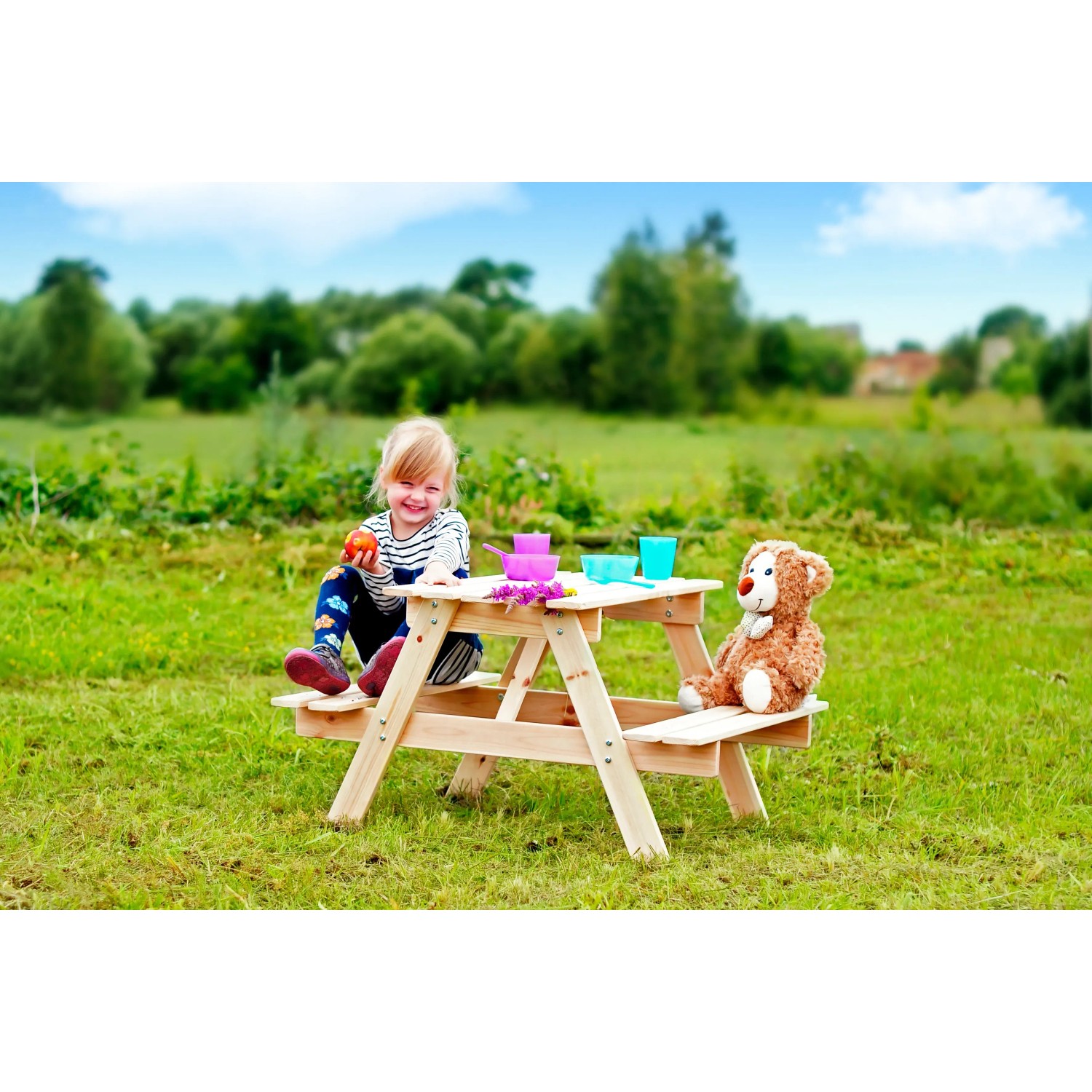 Timbela Kindersitzgarnitur M012-1: Holztisch mit Kind und Teddy im Garten.