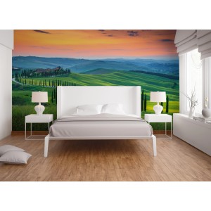 Fototapete Toskana Landschaft in Grün, Orange und Gelb hinter einem Bett. Hügel und Zypressenallee im Sonnenuntergang.