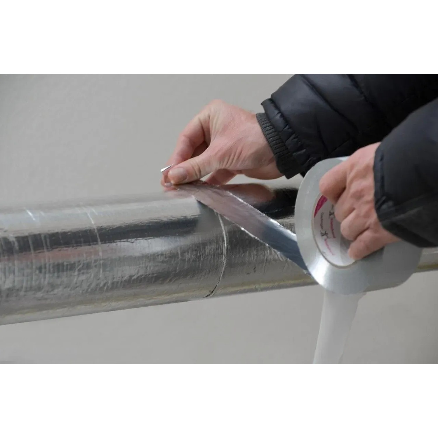 Hände verkleben silbernes Reinaluminium Klebeband auf Rohrisolierung. Ideal für Dämmstoffzubehör.