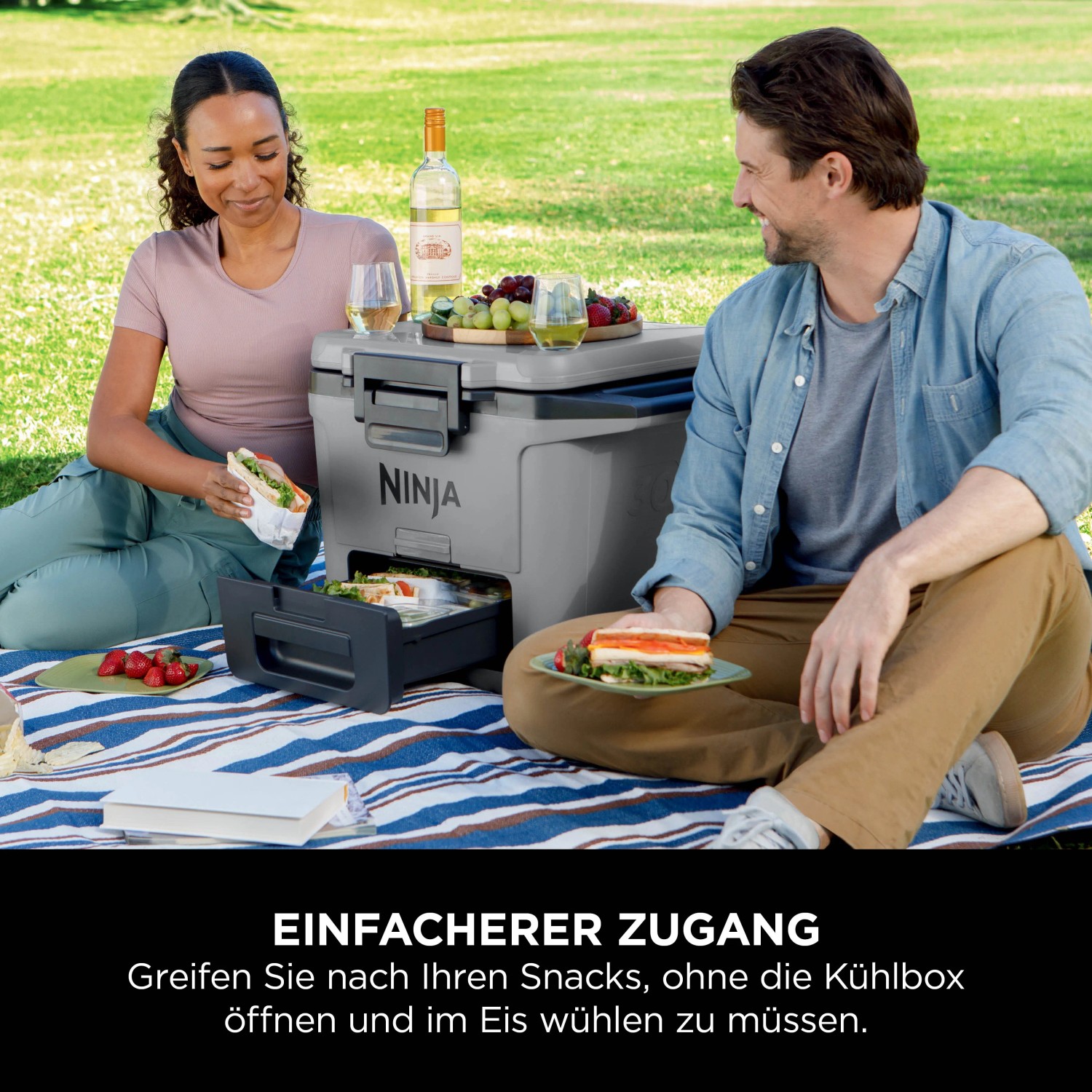 Ninja Kühlbox FrostVault mit Trockenzone in Schiefergrau, genutzt von zwei Personen im Freien.