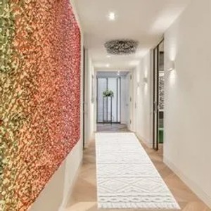 Langer, schmaler, pastell-cremefarbener Hochflor-Teppich Nara mit Boho-Rautenmuster im Flur.