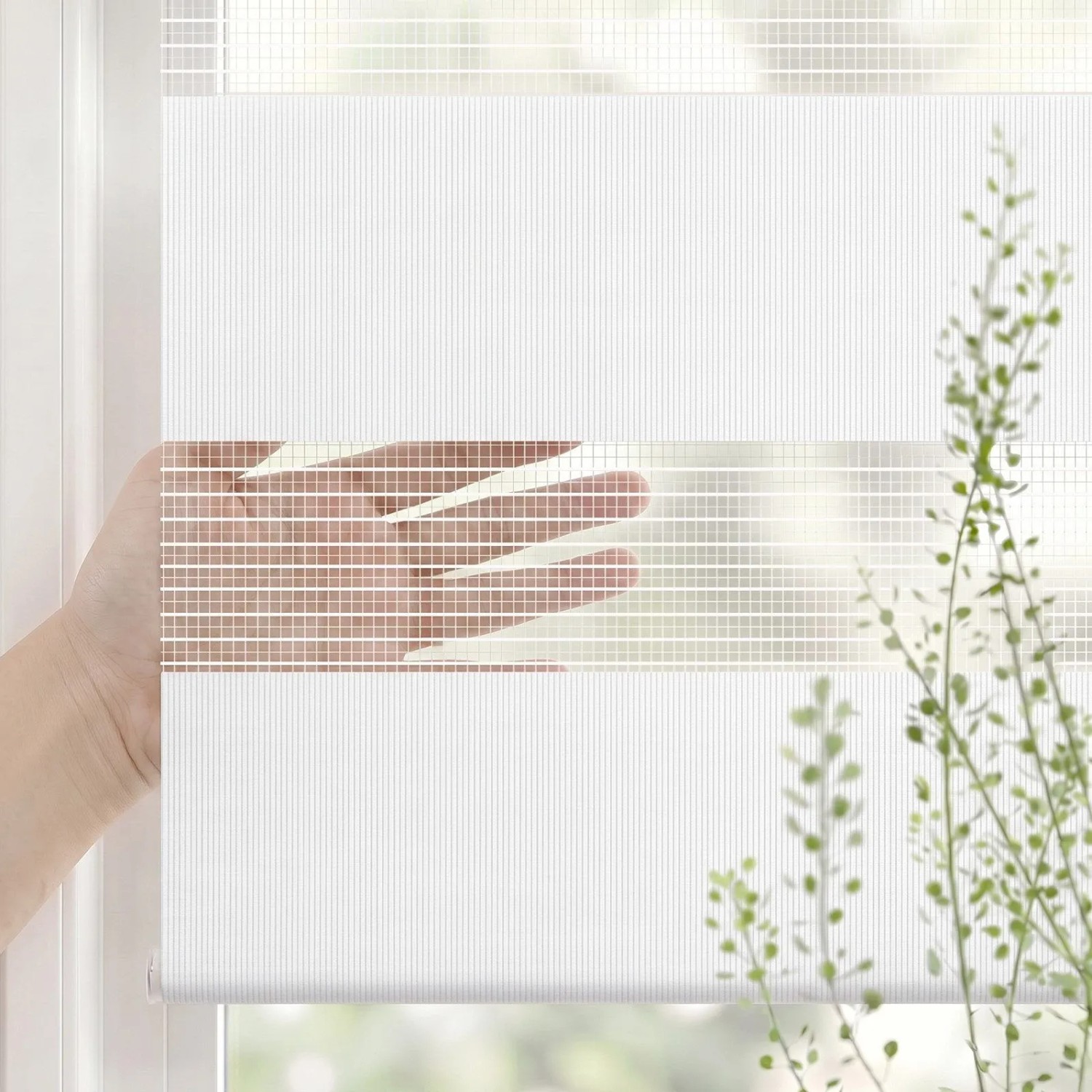 Weißes SALCAR Doppelrollo mit transparenten und blickdichten Streifen am Fenster. Hand zeigt regulierbaren Sichtschutz.
