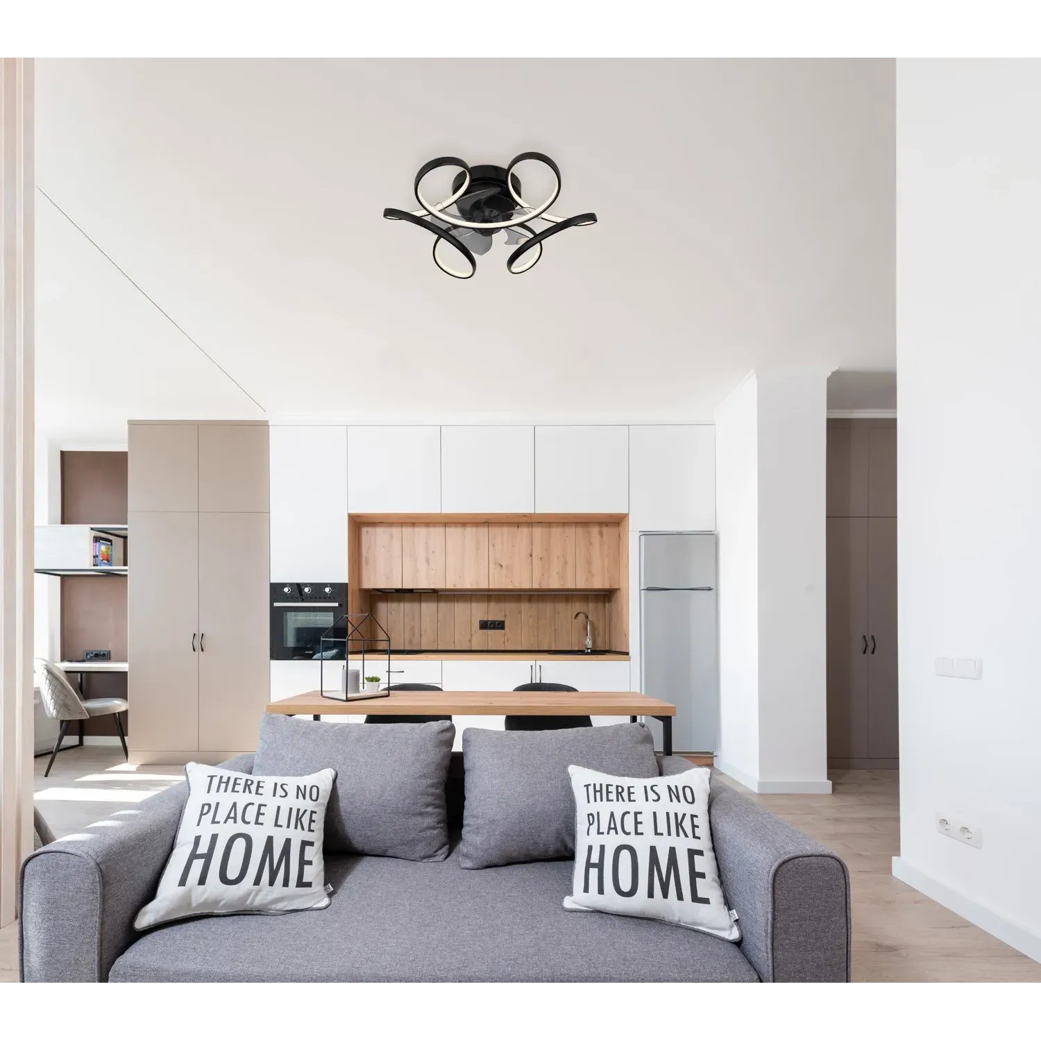 Schwarzer LED-Deckenventilator Loris, Ø 56 cm, mit geschwungenen Armen im modernen Wohnraum.