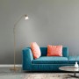 Paul Neuhaus Stehleuchte Pino in Altmessingfarben neben Sofa.