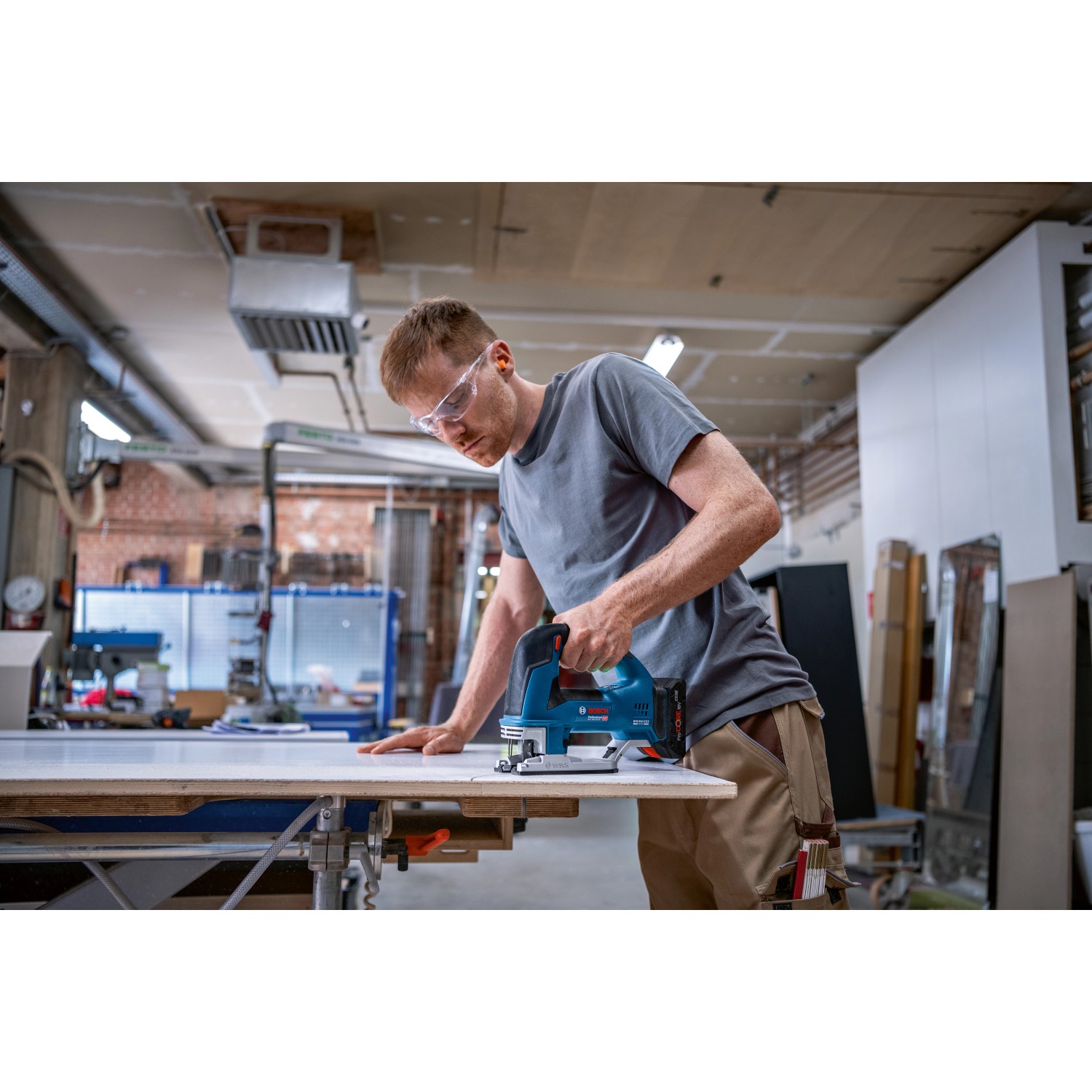 Mann arbeitet mit Bosch Professional Akku-Stichsäge GST 18 V-155 BC Solo an Werkbank.