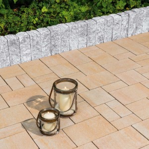 Diephaus Mauerstein Maximo Nola Granit als Gartenmauer und Bodenbelag mit Windlichtern.