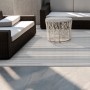 Gestreifter KARAT Outdoor Teppich Bologna (180x200 cm) auf Terrasse mit Möbeln.