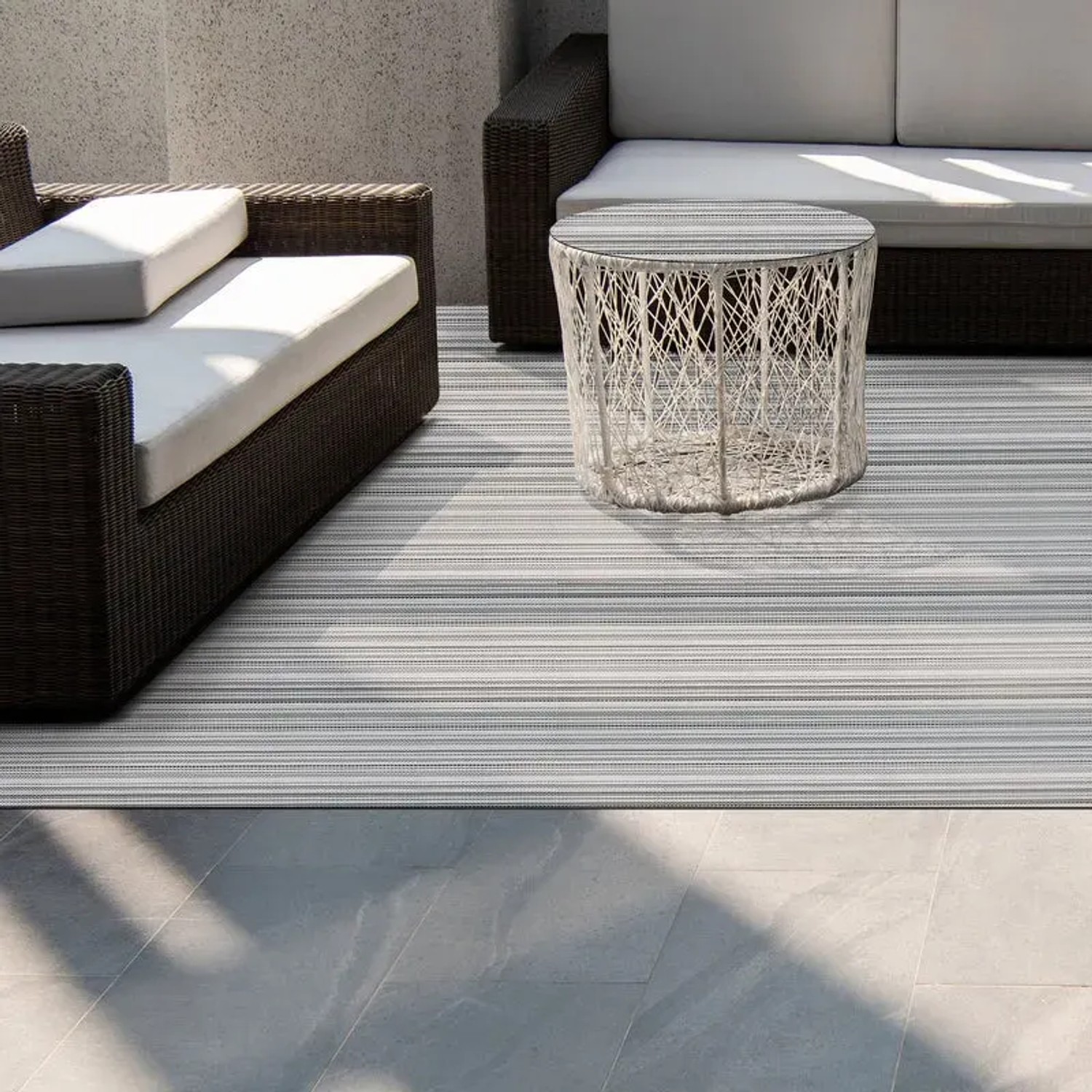 Gestreifter KARAT Outdoor Teppich Bologna (180x200 cm) auf Terrasse mit Möbeln.