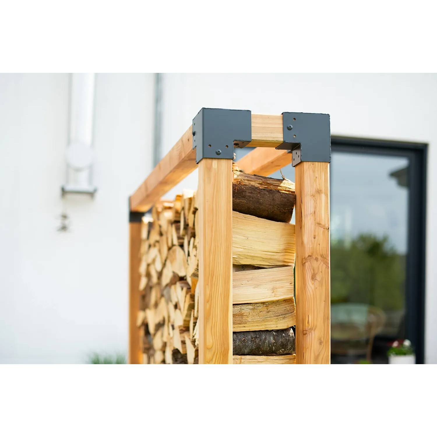 Westmann Kaminholzregal Michel XXL aus Lärchenholz, gefüllt mit Holzscheiten.
